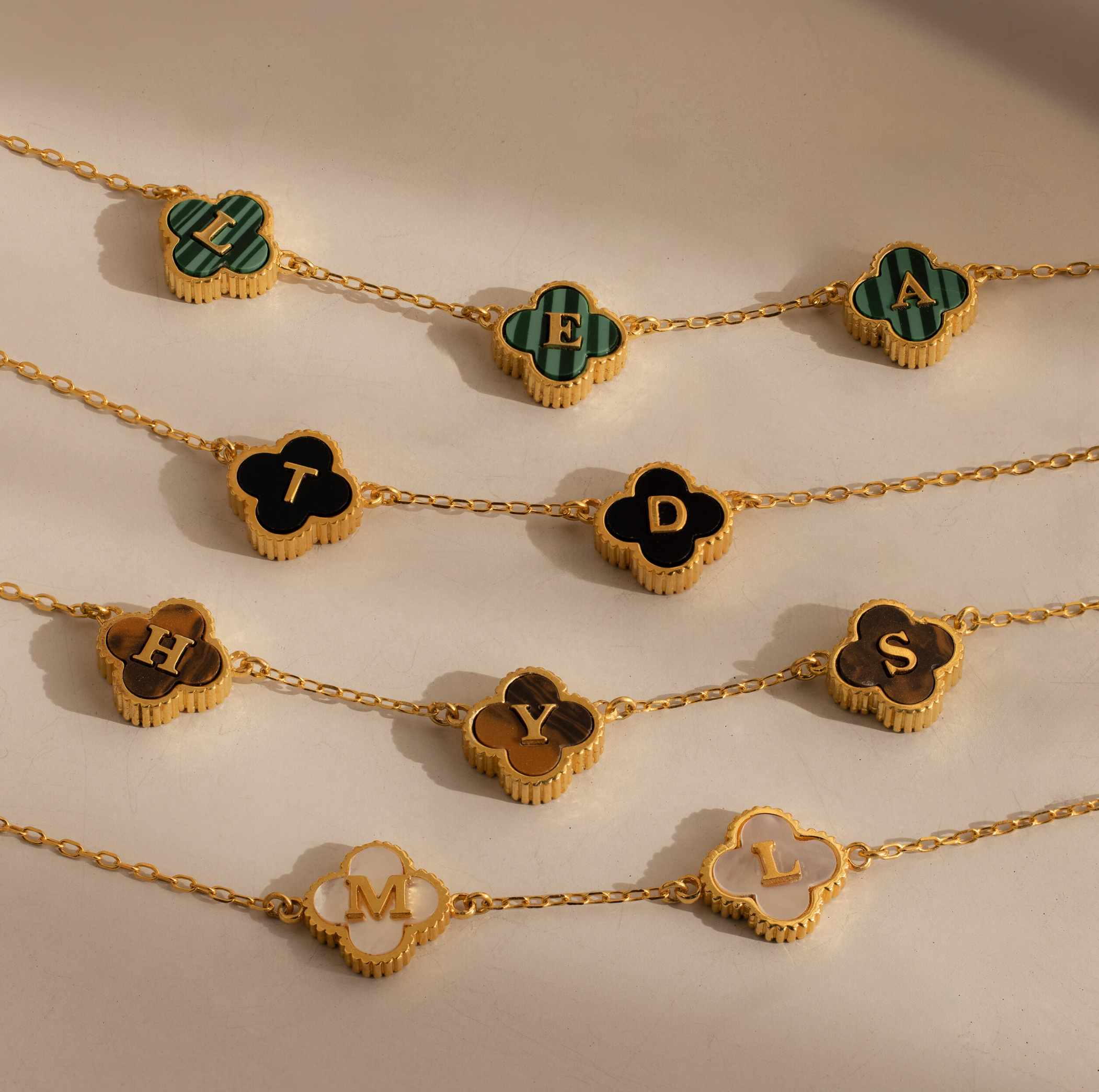 Gemstone Clover Letter Necklaces feature clover-shaped pendants, each with a single letter—L, E, A, T, H, Y, M, D—crafted in radiant 925 sterling silver and arranged on a neutral surface.