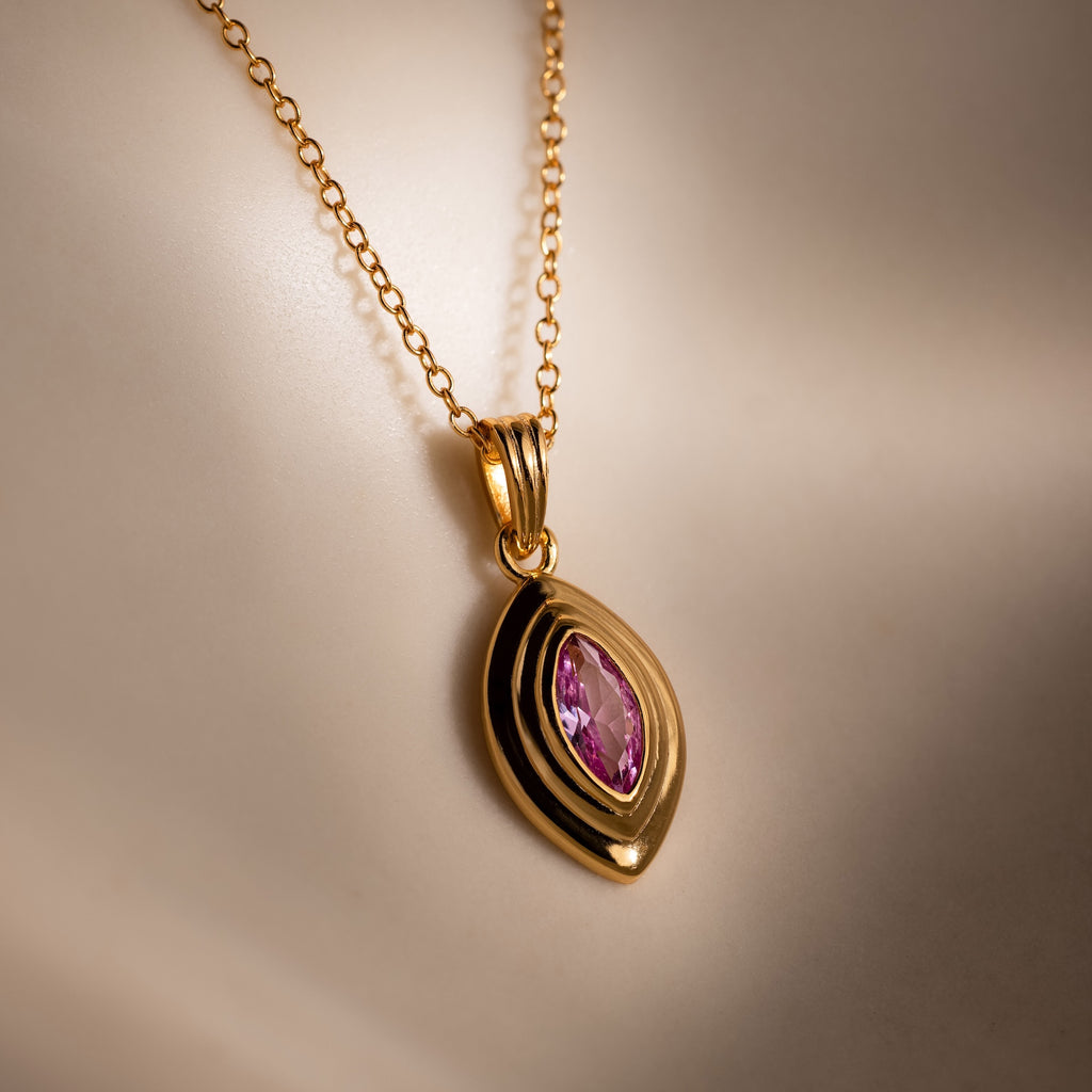 Ribbed Pink Tourmaline Pendant Necklace featuring a gold ribbed chain and pink tourmaline marquise gemstone, displaying a delicate birthstone pendant design on a smooth, neutral background.