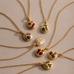 Seven gold necklaces, including the Mixed Amethyst Capsule Pendant Necklace plus birthstone and capsule styles, arranged in a vibrant circular pattern.