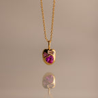 The Mixed Pink Tourmaline Capsule Necklace features pink and clear gemstones set in gold, shown against a neutral background.