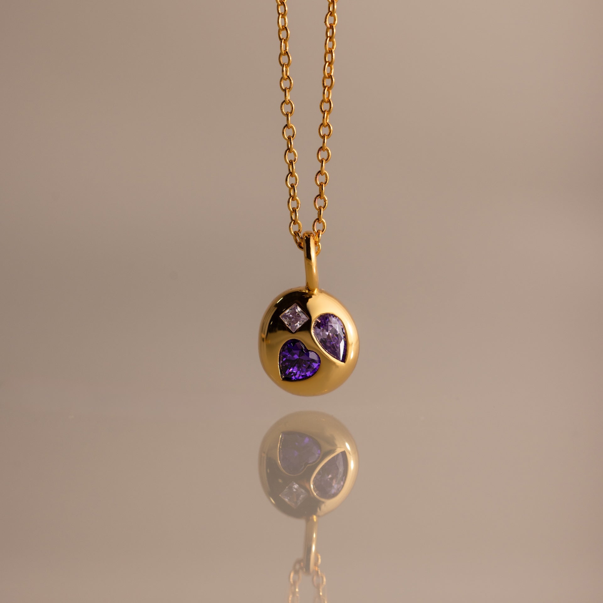 Mixed Birthstone Capsule Necklace in Alexandrite (June), featuring a round pendant with three purple gemstones in varying shapes, shown on a neutral background.