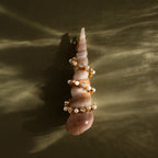 A Pearl & Diamond Tennis Bracelet, set against a textured olive-green background, evokes the refined elegance of luxury jewelry.