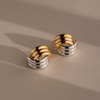 The Ribbed Mixed Metal Studs in gold and silver feature a sculpted, ribbed design, making these earrings a standout accessory against any neutral backdrop.