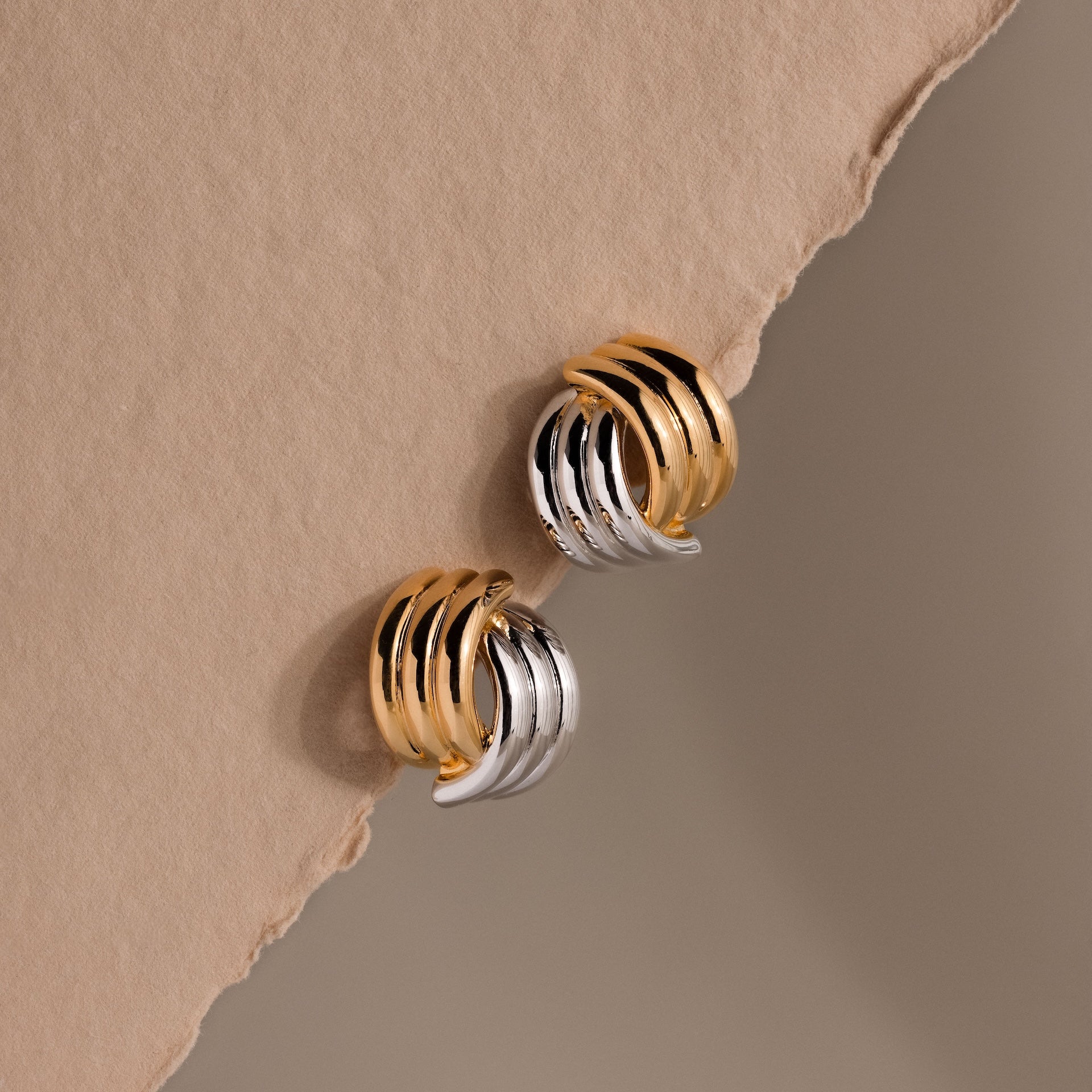 The Ribbed Mixed Metal Studs are sculpted gold and silver earrings that add a modern twist to classic style with their unique ridged design.