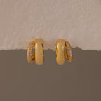 Duo Pave Dome Studs in 18K Gold feature one half plain and the other half pavé-set with clear crystals, making them perfect for everyday wear. Shown against a neutral background.