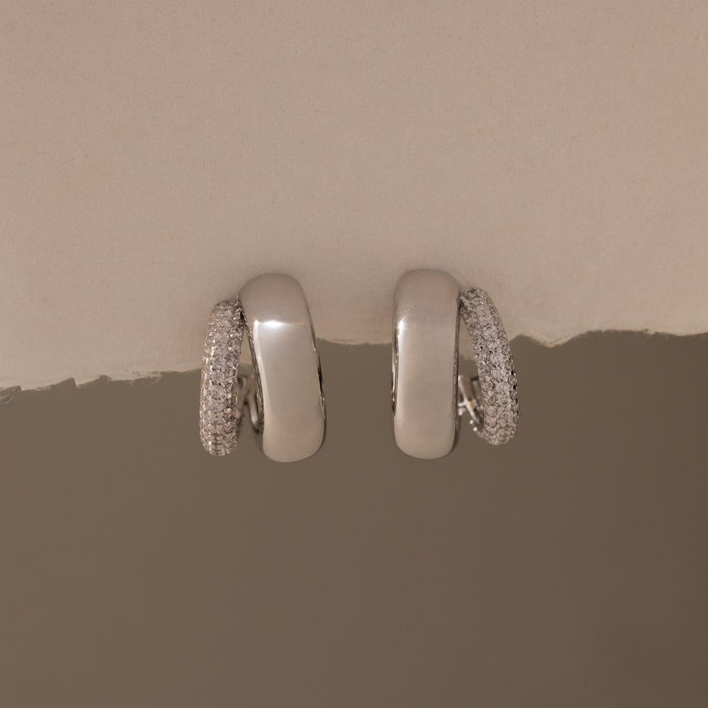 The Duo Pave Dome Studs in White Gold feature one plain and one pavé-encrusted earring, perfect for adding a subtle sparkle to your everyday jewelry collection.