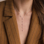 A woman wearing a brown pinstripe blazer and a Lariat Name Necklace.