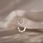 Two elegant Pearl Bead Necklaces—one gold, one silver—adorned with white pearls and displayed on beige fabric; ideal as a bridesmaid or Mothers Day gift.