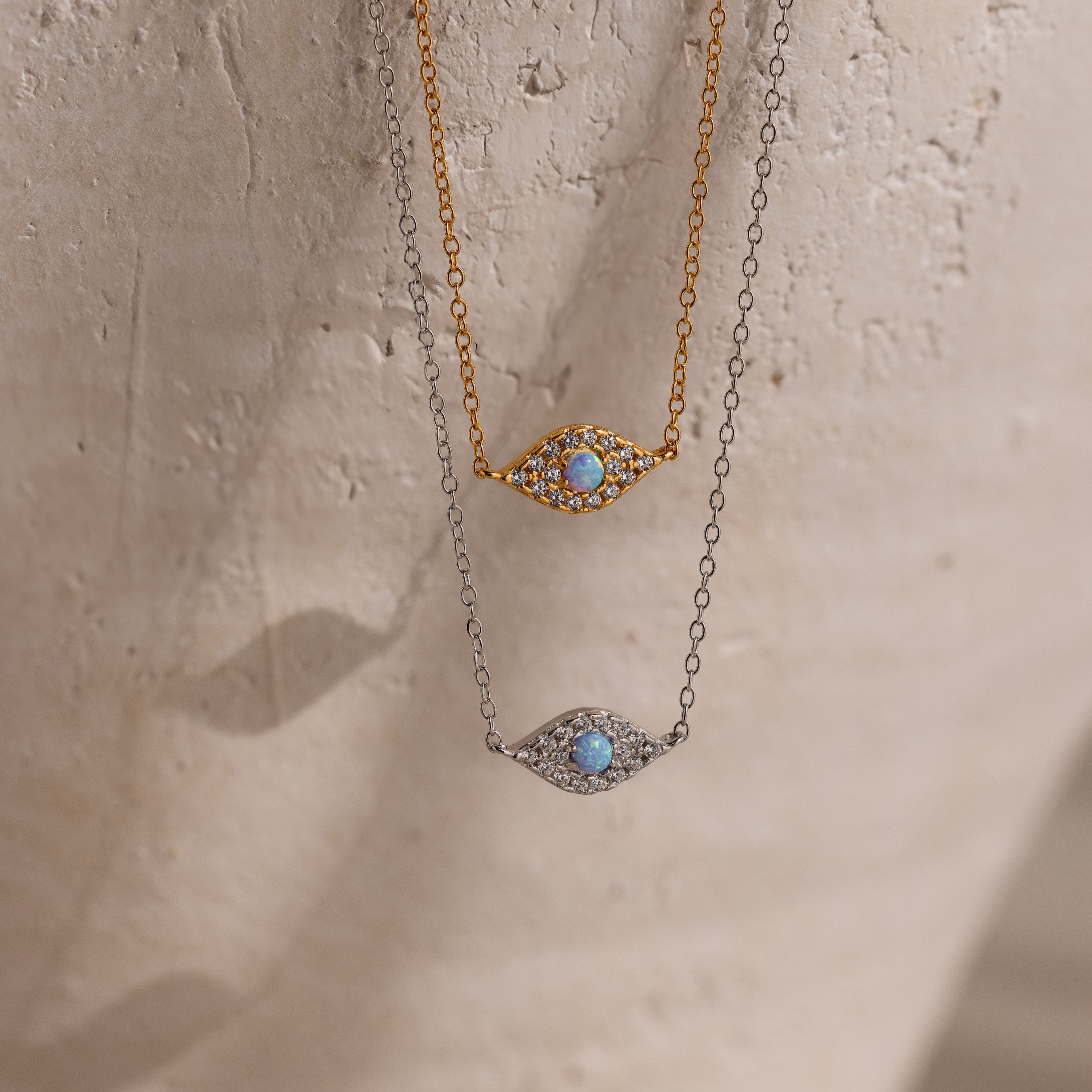 Two Opal Eye Necklaces—one in gold, one in silver—each with a blue stone center. Wear as an eye pendant or lucky talisman.