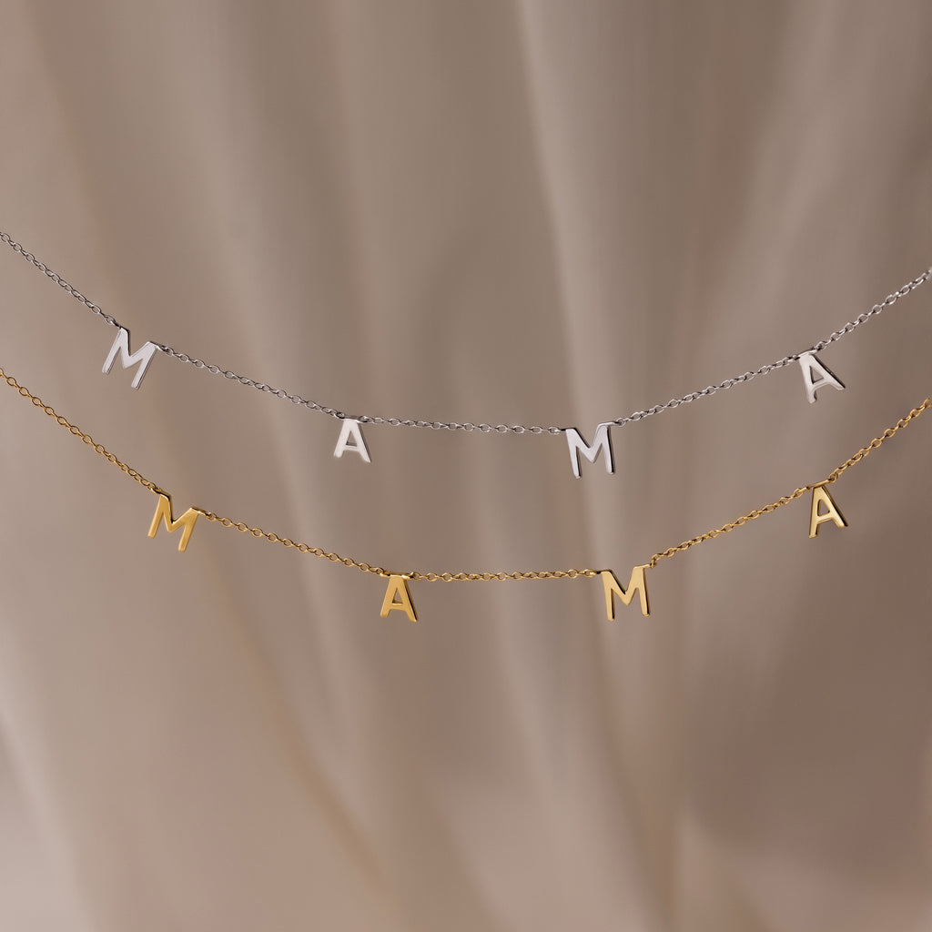 The Mama Letter Necklace—available in gold or silver—is elegantly displayed on a soft beige background, making it a perfect gift to celebrate motherhood.