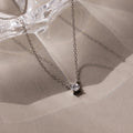The Dainty Diamond Necklace in Silver, featuring a solitaire pendant on a neutral background, makes an elegant Christmas gift for someone special.