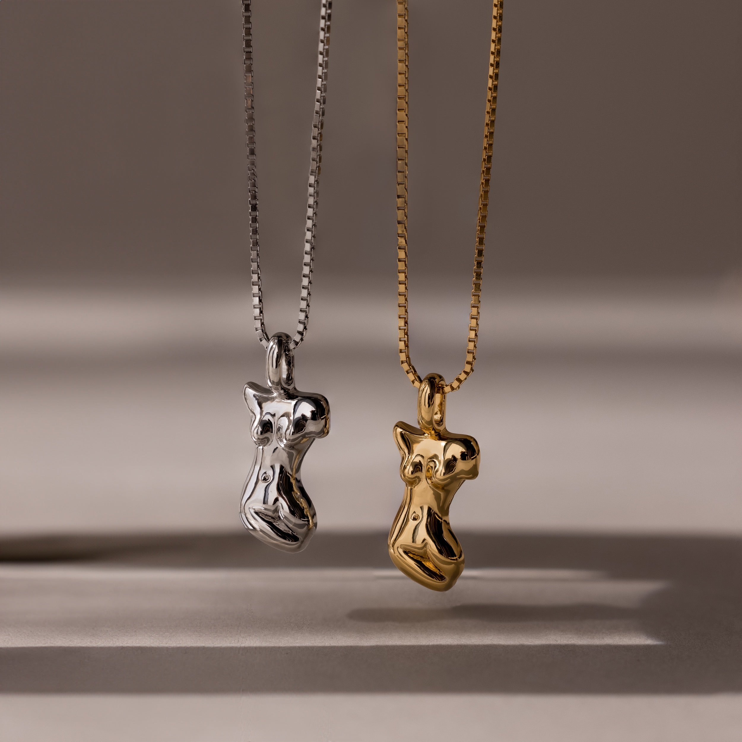 The Kinn Body Necklace is featured in gold and silver with an abstract body pendant, offering unique empowerment jewelry for bold style lovers.