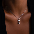 The Kinn Body Necklace in Silver, styled over a black top, adds a bold touch of empowerment to any look.