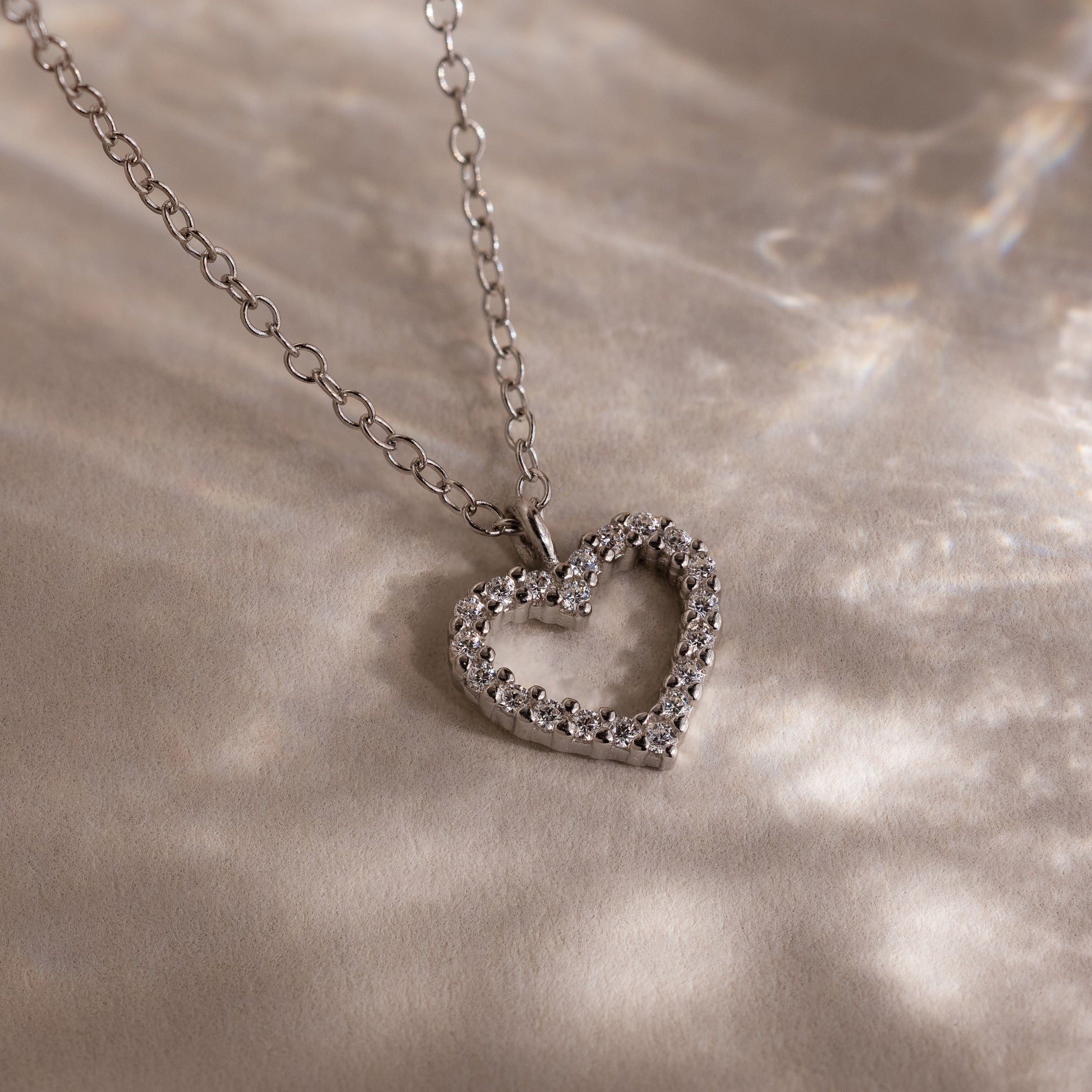 The Forever Pave Heart Necklace in Silver features small sparkling stones on a delicate chain—an elegant choice for bridal jewelry.
