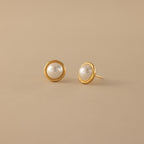 The Pearl Bezel Studs—gold stud earrings with round white pearls—add timeless elegance to any look, making them a perfect choice for every occasion.