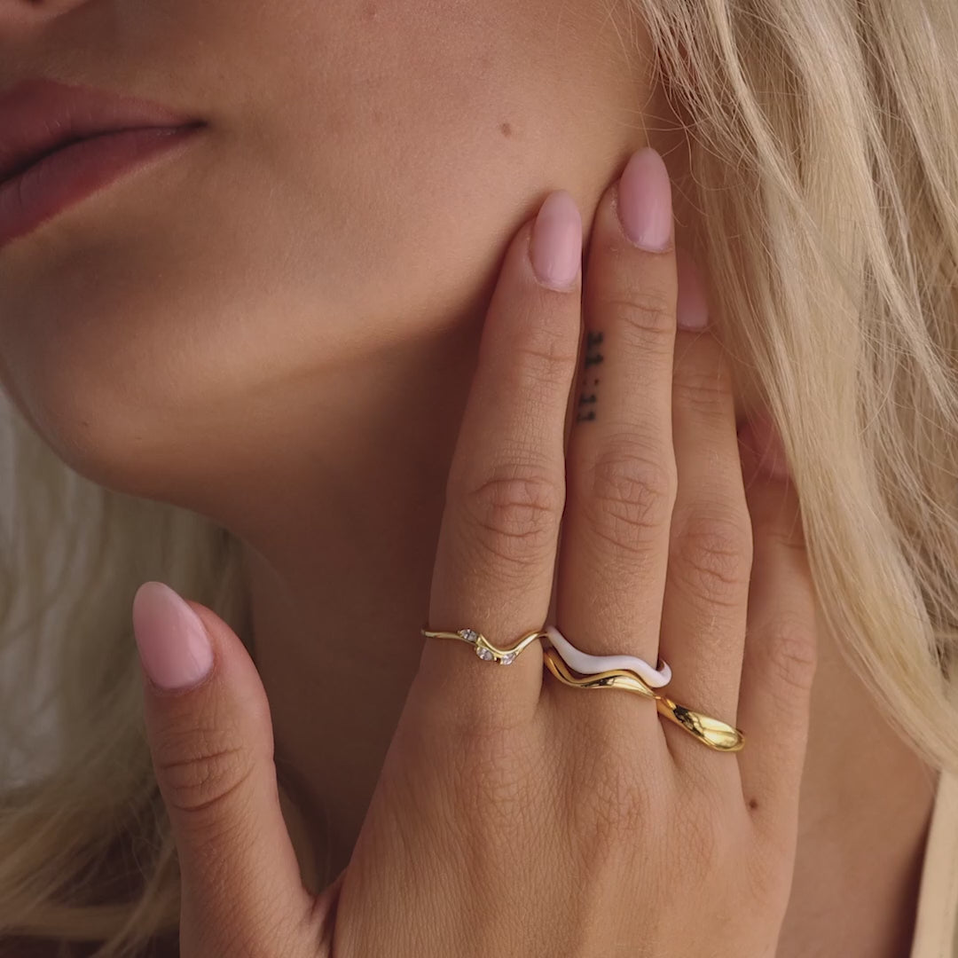 Gold Marquise Diamond Curve Ring on hand, featuring a fluid wave-like band accented with marquise-cut diamonds, styled alongside other gold statement rings.