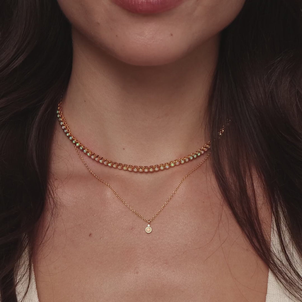 Video of a model wearing our Opal Diamond Necklace in Gold, styled with our Opal Bezel Tennis Necklace