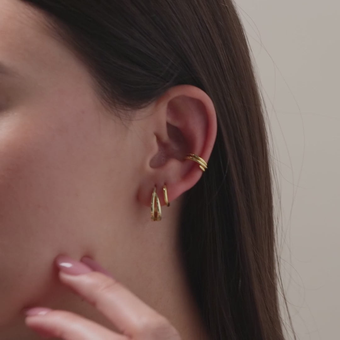 Video of a model wearing our Oval Duo Hoops in Gold, styled with our Claw Ear Cuffs