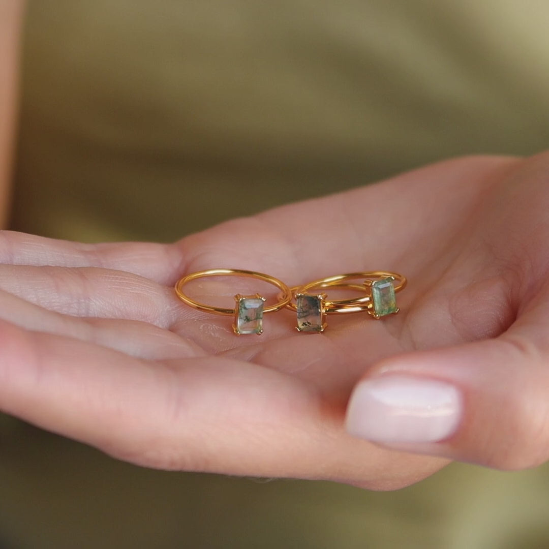 Three Agate Emerald Rings held in a hand, highlighting the natural variation in each stone's pattern and color.