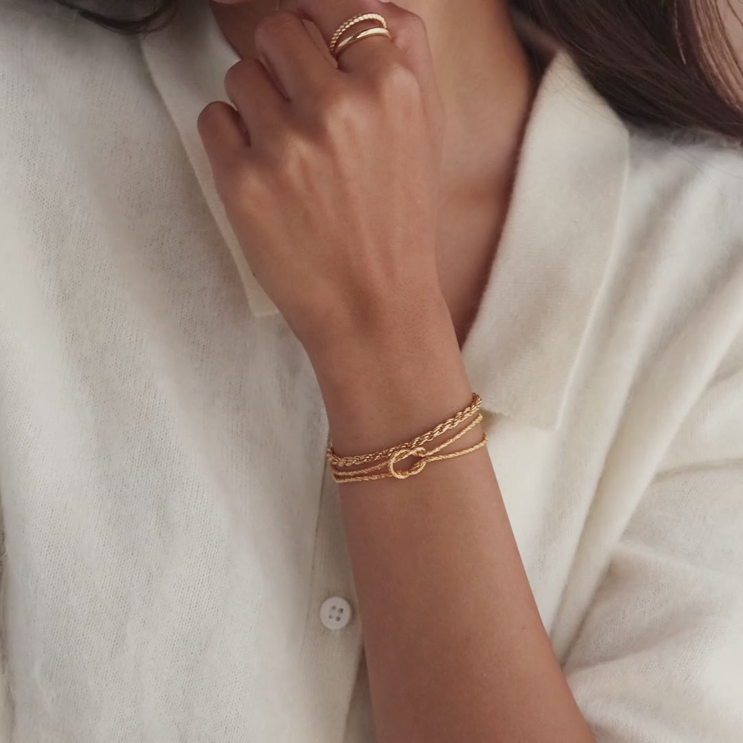 Model showcasing the Rope Knot Chain Bracelet in gold, styled with a matching gold rope chain bracelet and gold duo band ring.