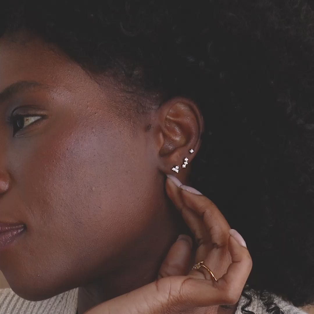 Model wearing set of 3 dainty gold CZ Diamond Constellation Stud Earrings as a stacked set