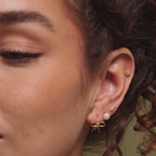 Video of a model wearing our Tiny Bow Flatback Studs in 18K Gold, styled with our Pearl Studs and Bow Huggies