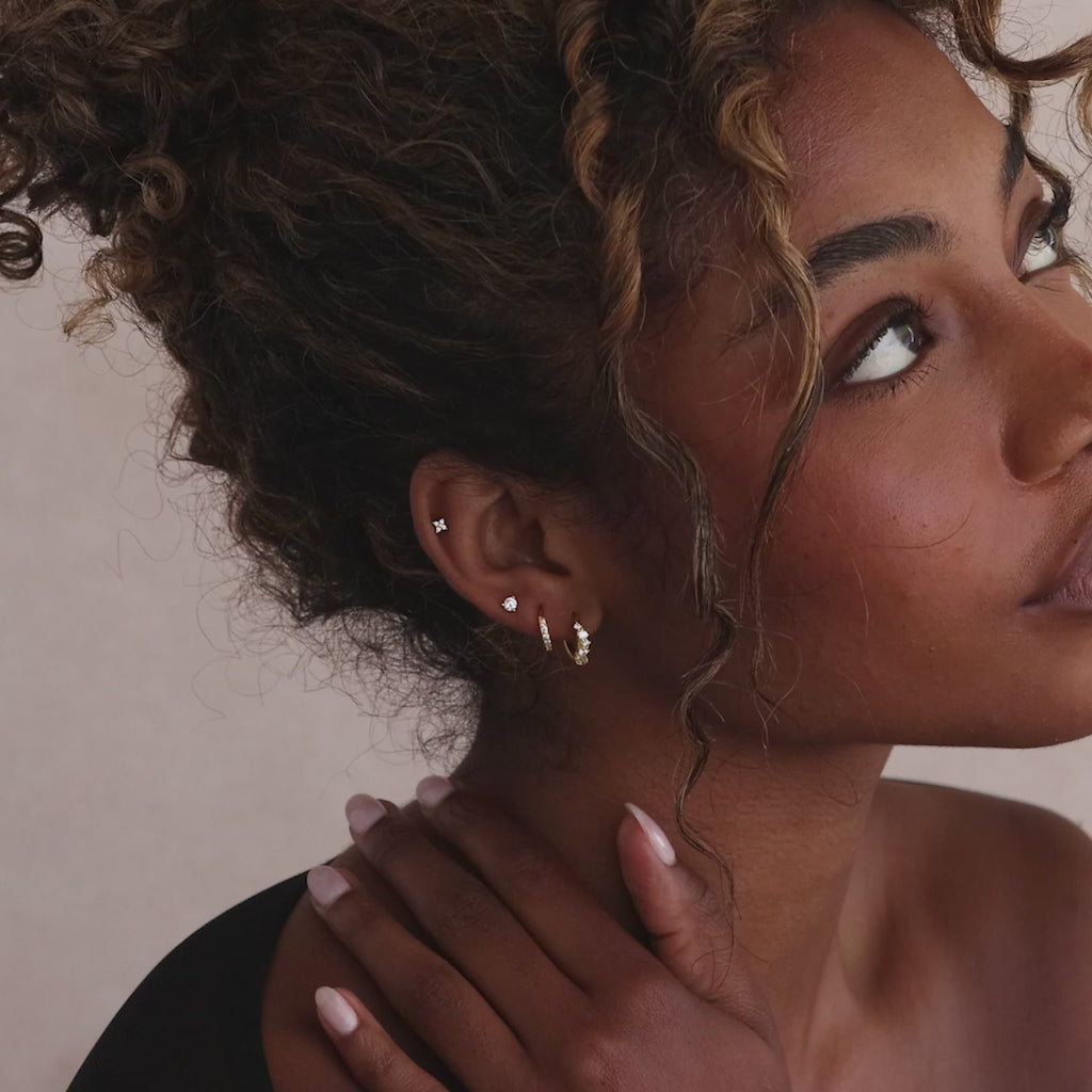 Model showcasing gold Marquise Cluster Hoop Earrings with clustered CZ diamond stones, stacked with multiple gold diamond earrings.