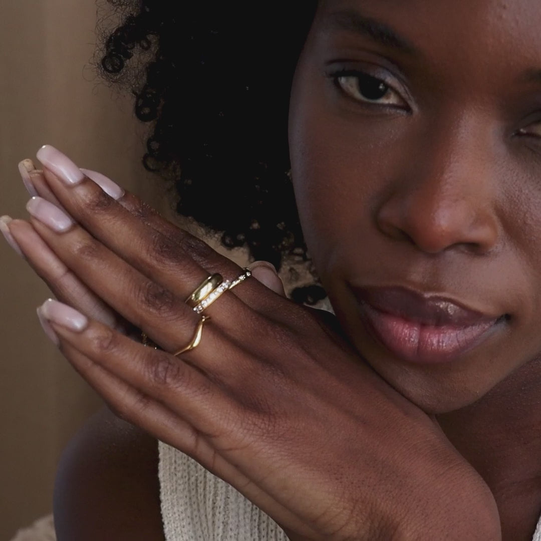 Model wearing stacked set of gold cz diamond rings.