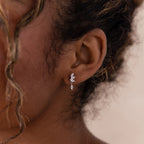 Model wearing silver CZ diamond drop earrings with four marquise-cut stones.