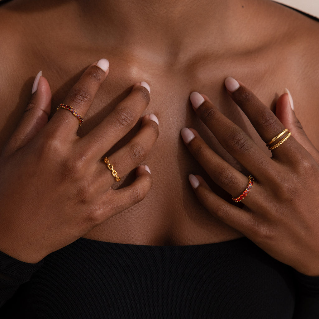 Model wearing a gold Red Marquise Ombre Ring with gradient marquise-cut stones, stacked with multiple gold rings.
