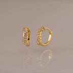 Marquise Cluster Hoop Earrings in gold with clustered CZ diamond stones, shown standing on a soft neutral surface.