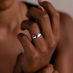 A close-up of a hand wearing the Duo Form Ring Set in Silver on the middle finger against a neutral background.
