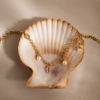Seaside Pearl Charm Bracelet in 18K Gold features pearl, shell, and starfish ocean-inspired charms—perfect for those who love beachy jewelry.