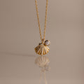 Diamond Seashell Charm Necklace in 18K Gold features a shell pendant and diamond charm, perfect for adding coastal style to any look.