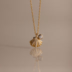 Diamond Seashell Charm Necklace in 18K Gold features a shell pendant and diamond charm, perfect for adding coastal style to any look.