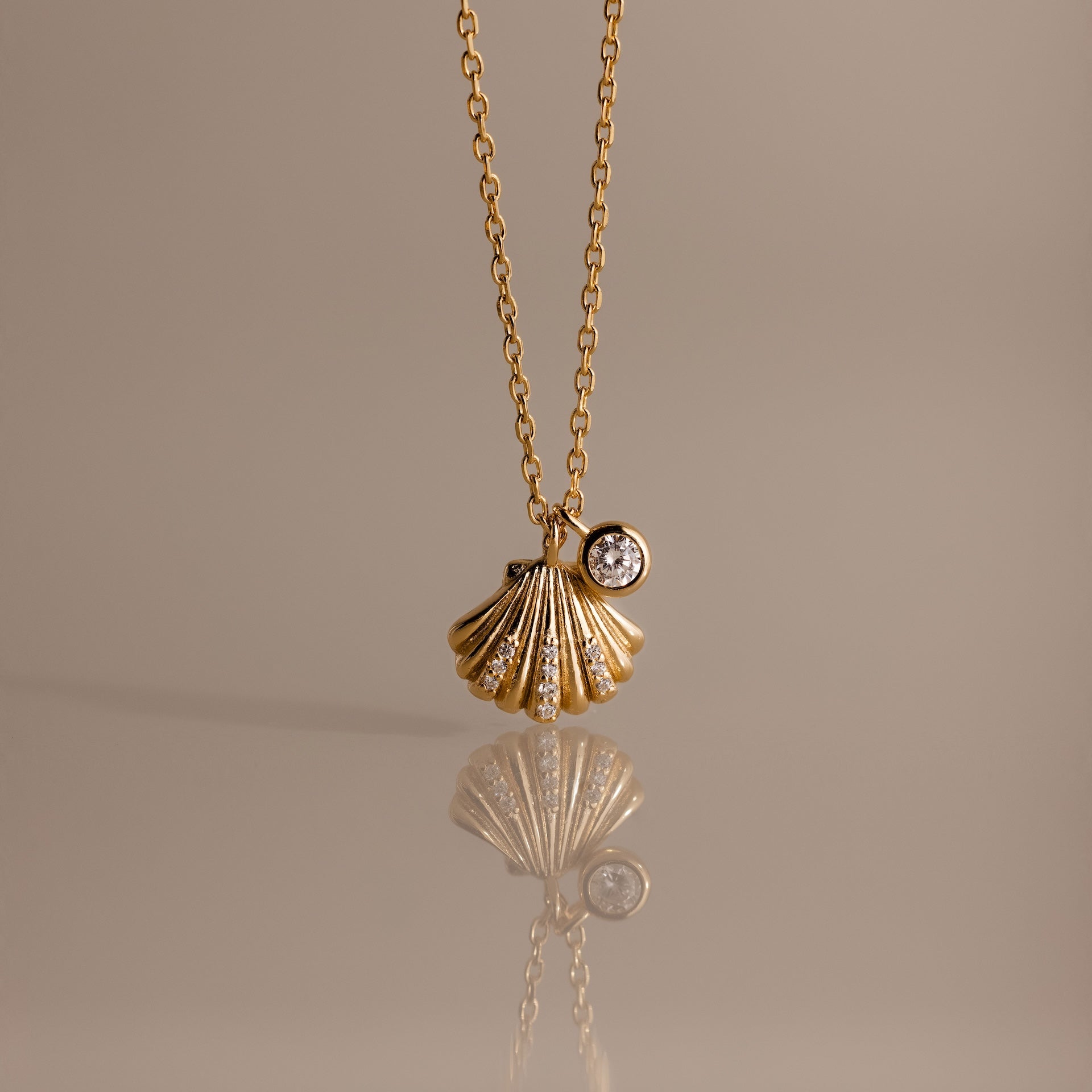 Diamond Seashell Charm Necklace in 18K Gold features a shell pendant and diamond charm, perfect for adding coastal style to any look.