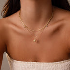 A woman wears a white textured strapless top and the Diamond Seashell Charm Necklace, creating a perfect look for coastal jewelry lovers.