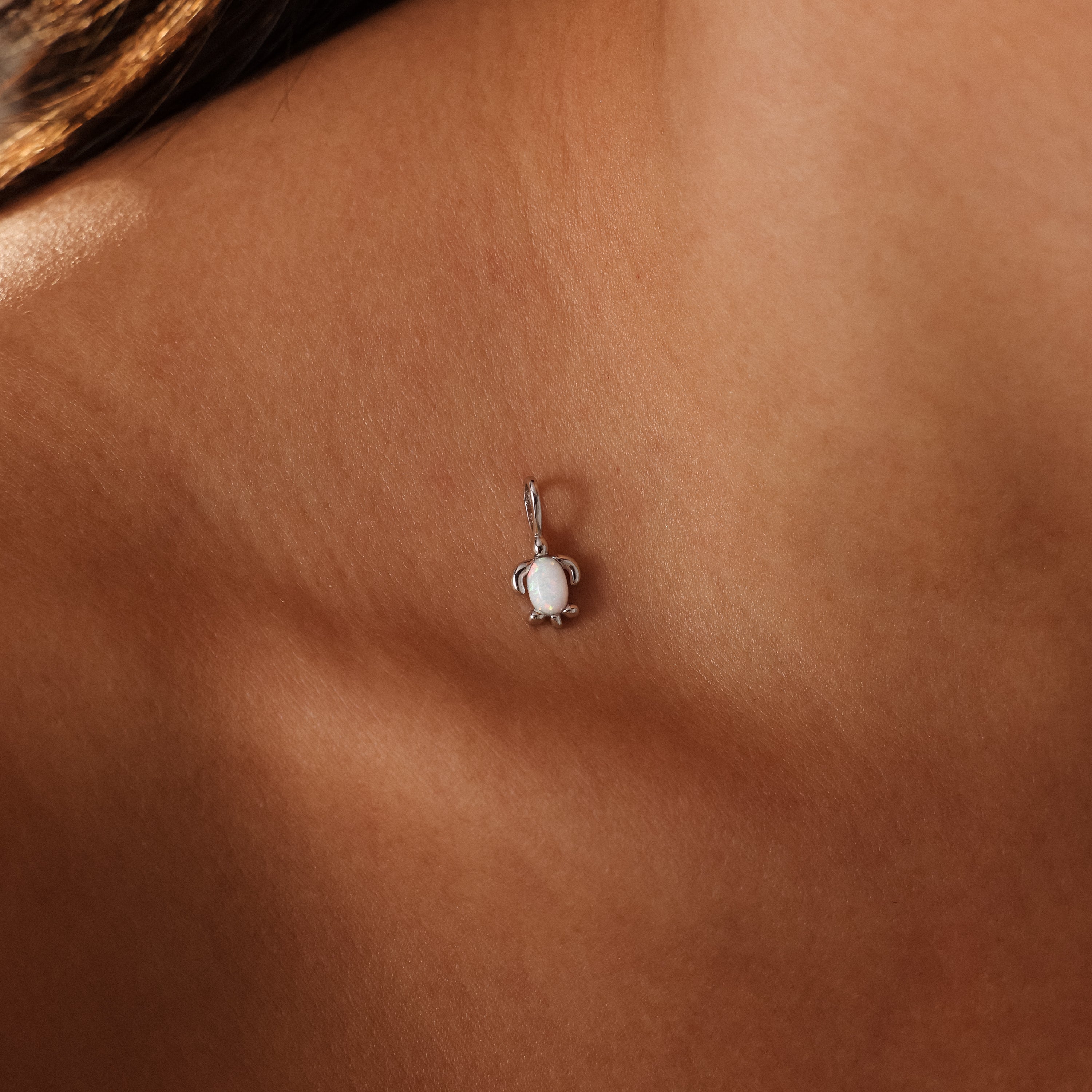 The Opal Sea Turtle Charm in Silver necklace elegantly rests on the neck and collarbone, capturing the essence of ocean-inspired jewelry.