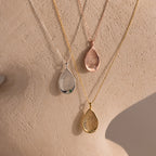 The Organic Fingerprint Teardrop Necklace features three pendants in silver, rose gold, and gold finishes, displayed on elegant chains draped over a neutral mannequin—perfect as a personalized fingerprint keepsake.