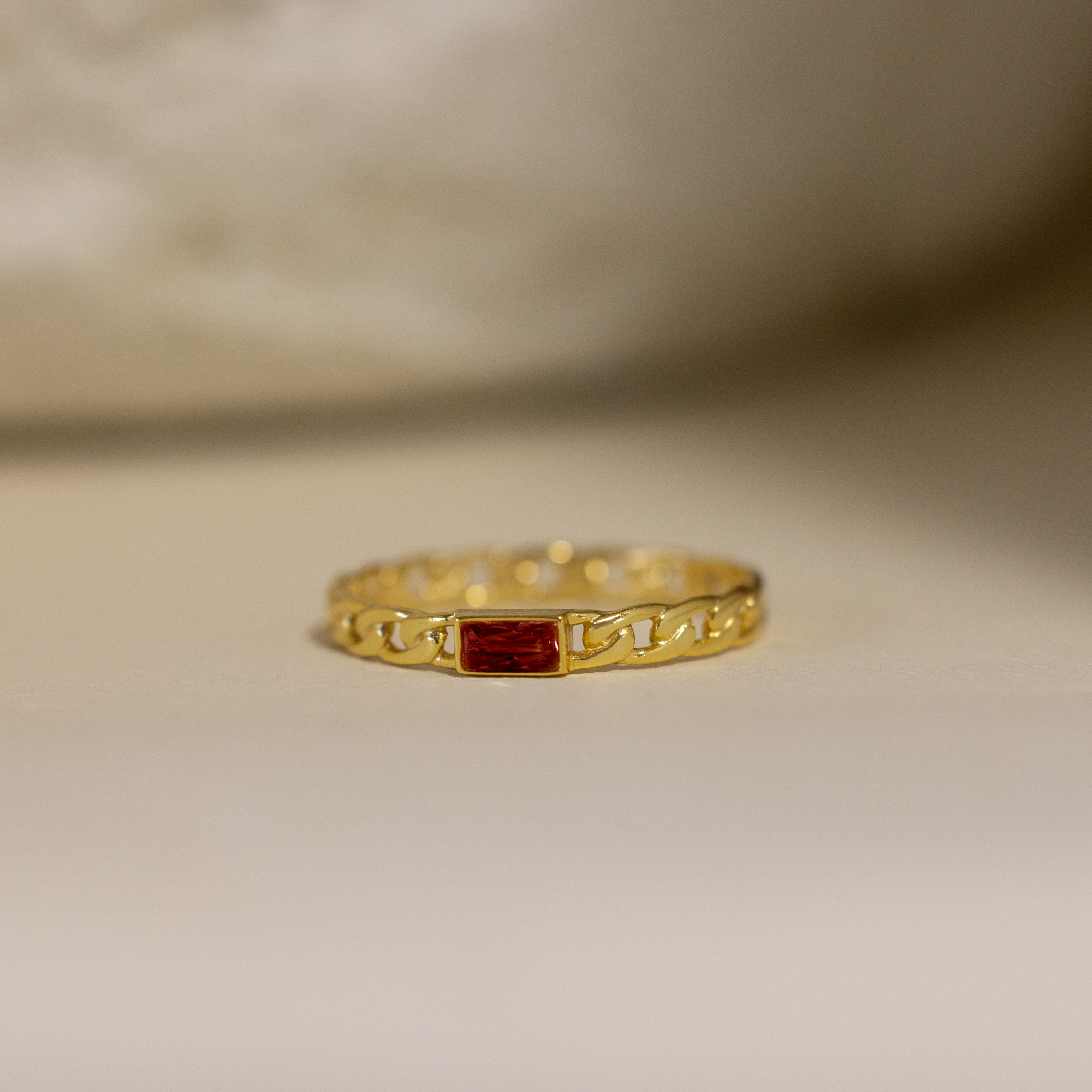 Baguette Birthstone Curb Ring in Garnet (January) features a rectangular red gemstone and a stylish curb-link band, displayed on a neutral background—ideal for fans of personalized, modern jewelry.