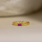 The Baguette Ruby Curb Ring features a gold curb-link band set with a rectangular pink gemstone, displayed on a neutral background.