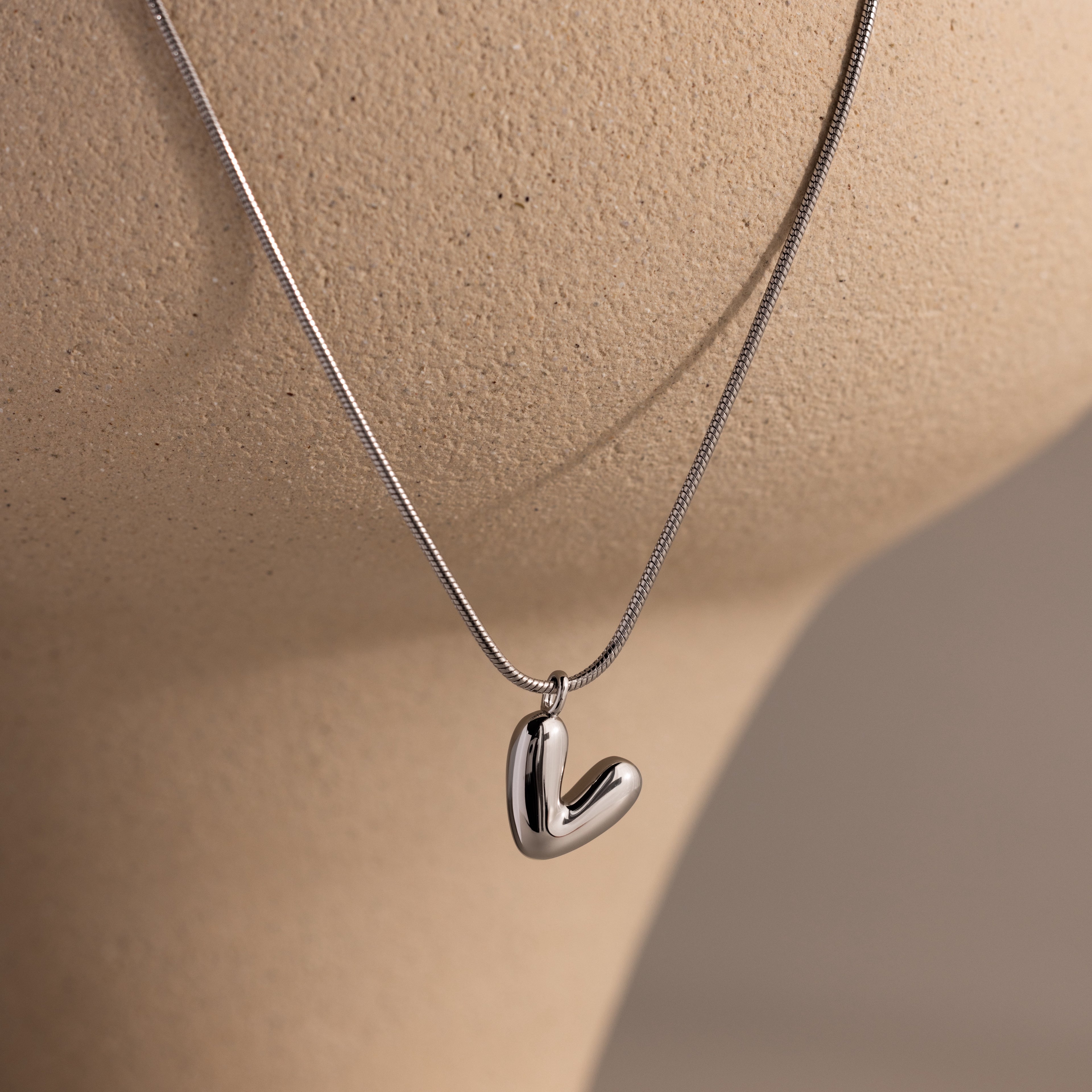 The Bubble Letter Necklace in white gold, ideal for fans of personalized jewelry, is shown on a beige mannequin bust.