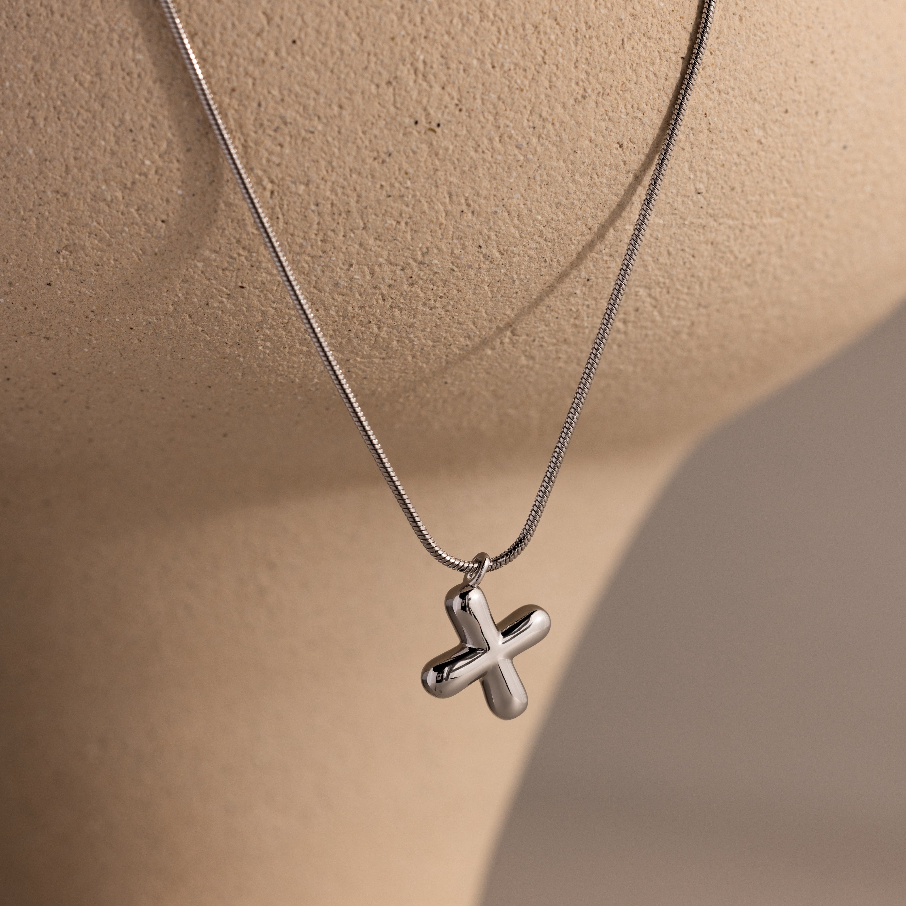 The Bubble Letter Necklace in White Gold, perfect for personalized jewelry enthusiasts, is showcased elegantly on a beige mannequin bust.