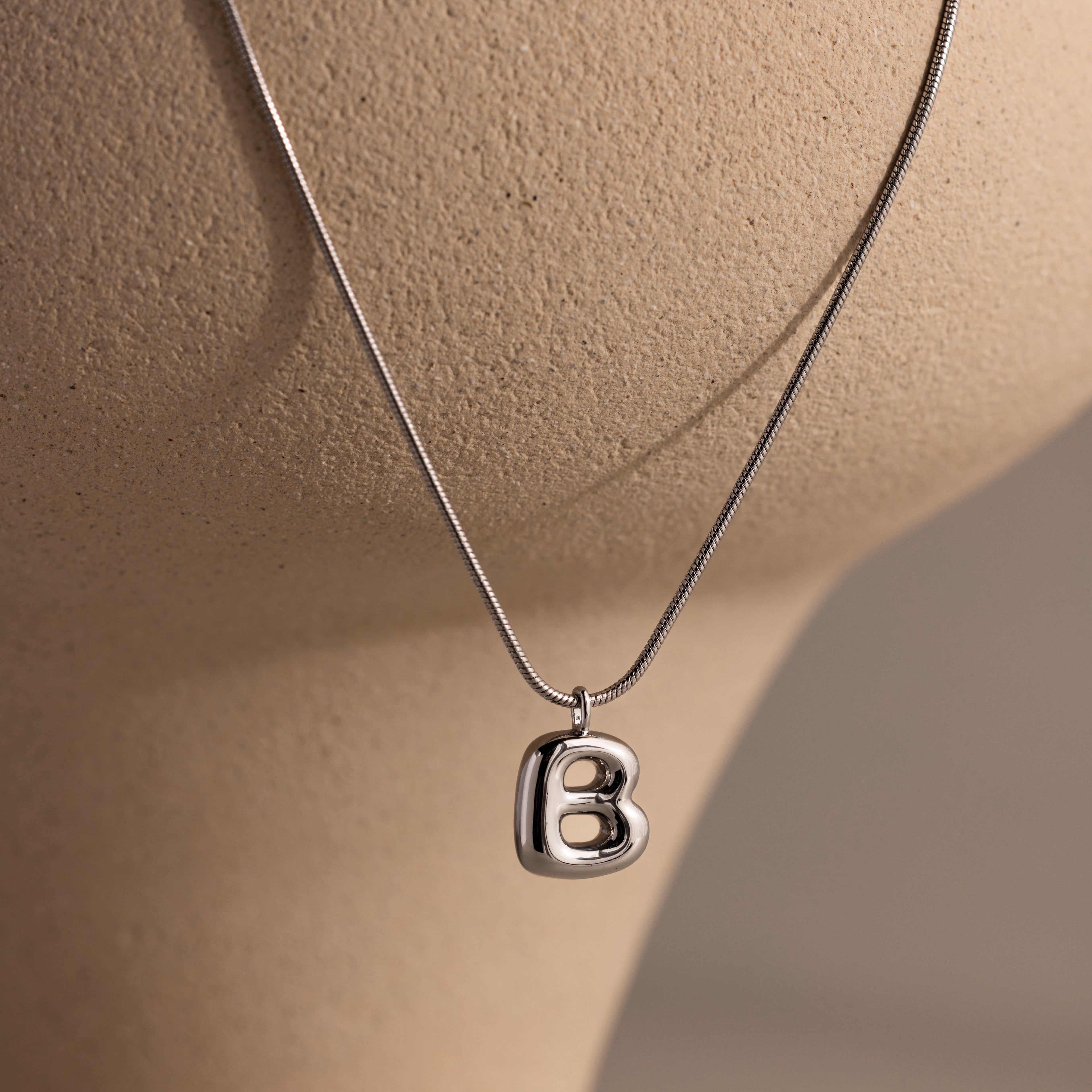 Bubble Letter Necklace in White Gold with a heart-shaped pendant featuring the letter B, displayed on a neutral bust—perfect personalized jewelry for any occasion.