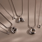 The Dainty Bubble Letter Necklace in Sterling Silver features large A, B, and C pendants with matching small charms—perfect for a personalized, minimalist look against a neutral background. Set includes four necklaces.