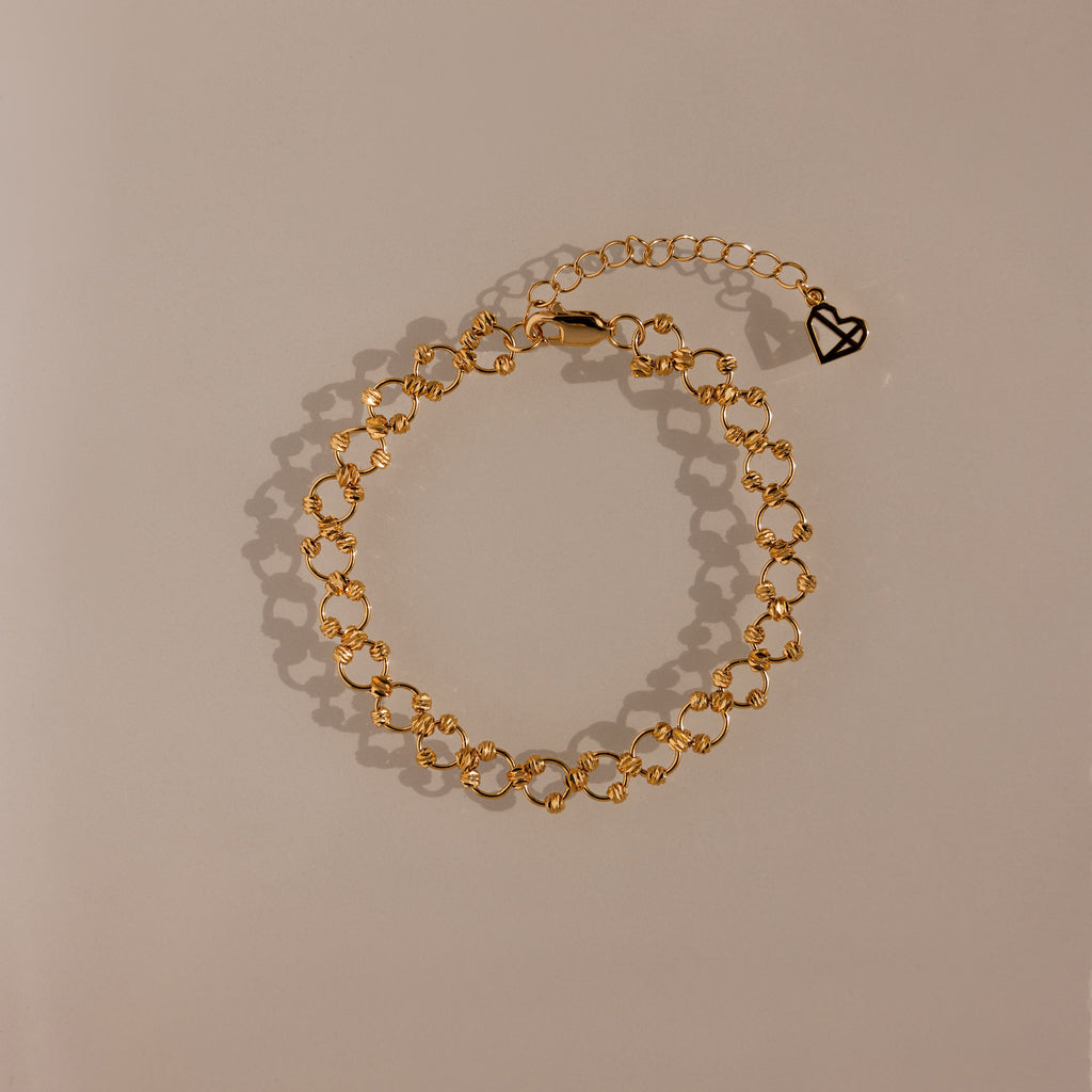 The Orbit Chain Bracelet in 18K Gold features small heart-shaped links and an adjustable clasp—an elegant piece that adds sophistication to any jewelry collection.