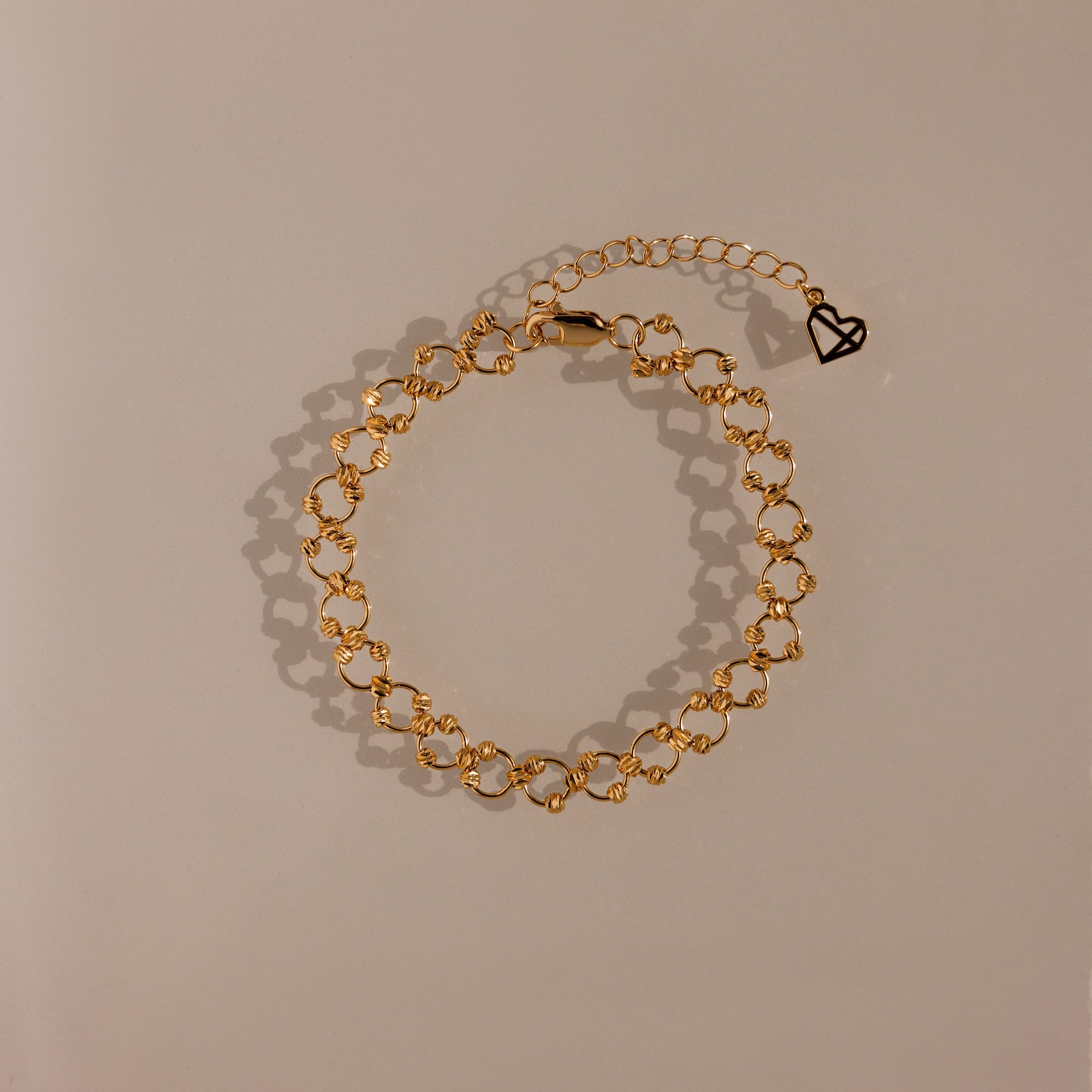 The Orbit Chain Bracelet in 18K Gold features small heart-shaped links and an adjustable clasp—an elegant piece that adds sophistication to any jewelry collection.