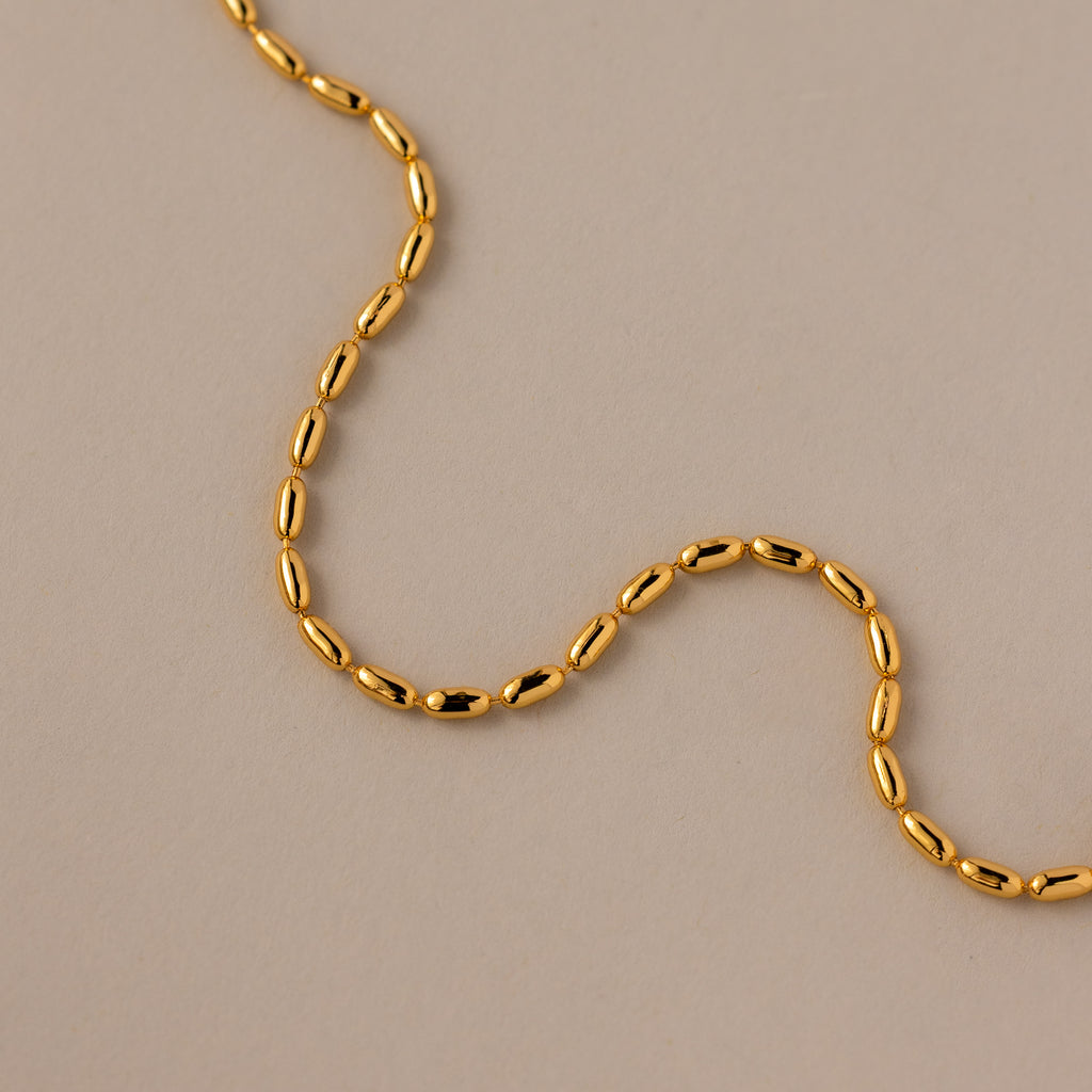 The Oval Beaded Bracelet in 18K Gold features polished beads arranged in a sleek design, making it a perfect choice for fans of modern jewelry.