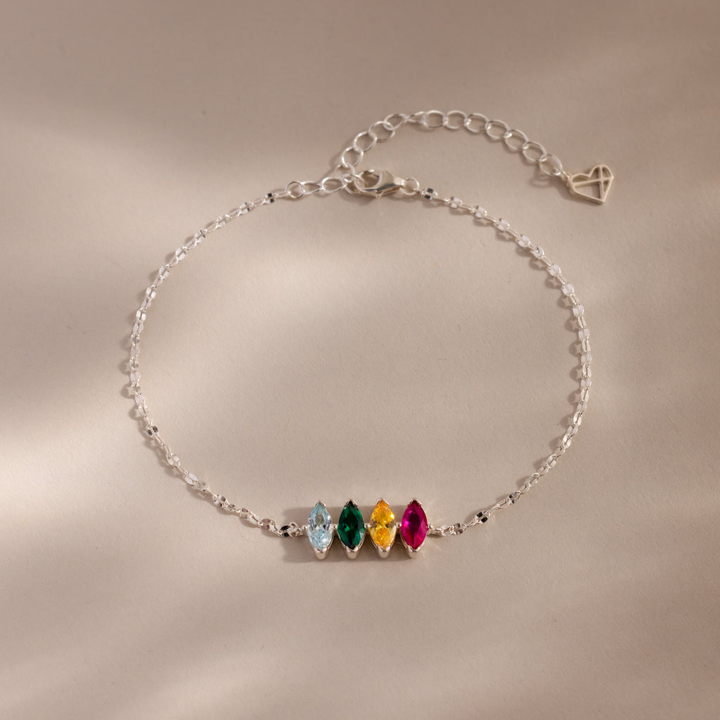 The Multiple Marquise Birthstone Bracelet in Sterling Silver features four colored gemstones and an adjustable chain, beautifully displayed on a neutral background. Perfect customizable jewelry for lovers of elegant birthstone bracelets.