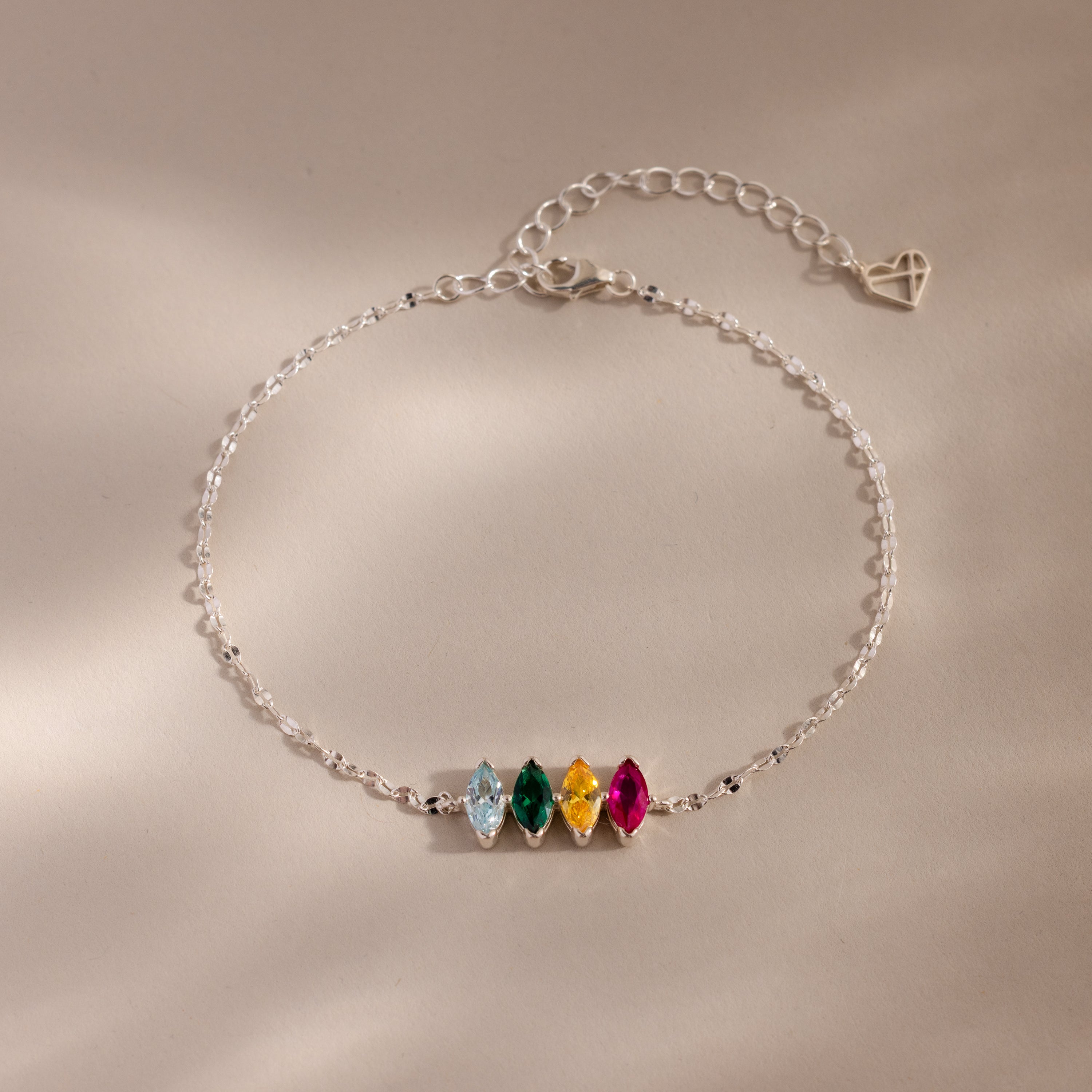 The Multiple Marquise Birthstone Bracelet in Sterling Silver features four colored gemstones and an adjustable chain, beautifully displayed on a neutral background. Perfect customizable jewelry for lovers of elegant birthstone bracelets.